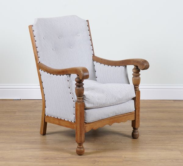 AN EARLY 20TH CENTURY OAK FRAMED LOW ARMCHAIR