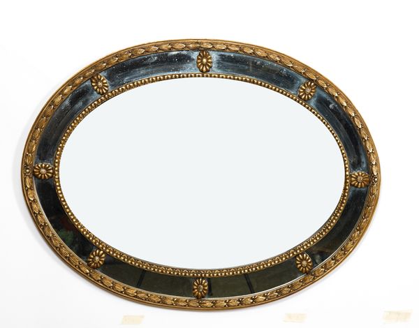 A REGENCY STYLE GOLD PAINTED OVAL MARGINAL WALL MIRROR