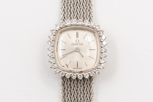 AN OMEGA DIAMOND WATCH AND A GILT METAL FOB WATCH (2)