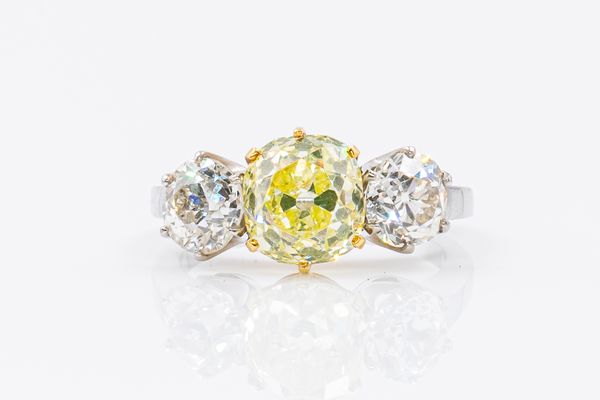 A YELLOW AND WHITE DIAMOND THREE STONE RING