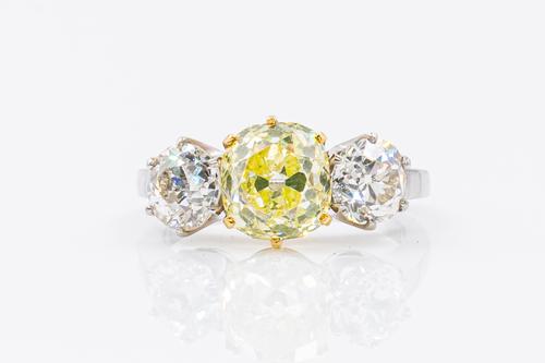 A YELLOW AND WHITE DIAMOND THREE STONE RING