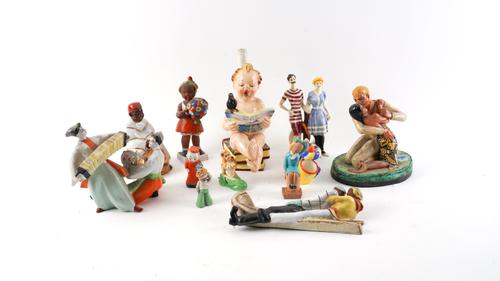 MOSTLY MID 20TH CENTURY CERAMIC FIGURES INCLUDING A SINGING CHERUB, A SLEDGING COUPLE, A ROMANTIC COUPLE AND NINE OTHERS (12)