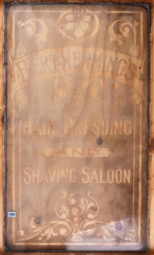 AN EARLY 20TH CENTURY ETCHED GLASS WINDOW FOR A HAIR DRESSING AND SHAVING SALON