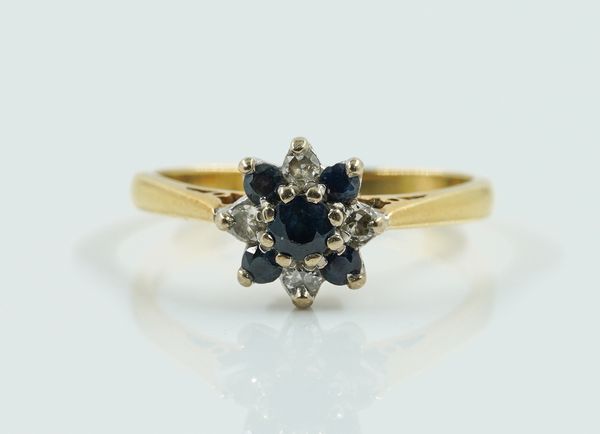 A GOLD, SAPPHIRE AND DIAMOND NINE STONE CLUSTER RING