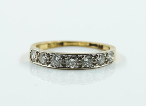AN 18CT GOLD AND DIAMOND SEVEN STONE HALF HOOP RING