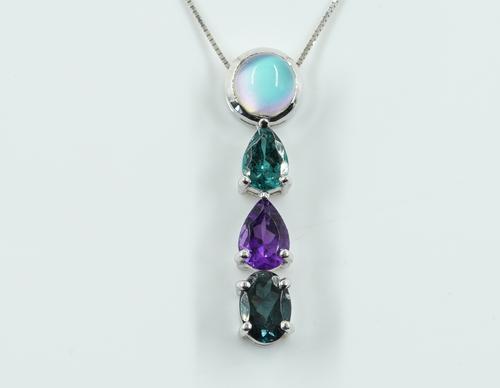 A WHITE GOLD AND VARICOLOURED GEM SET PENDANT WITH A WHITE GOLD NECKCHAIN
