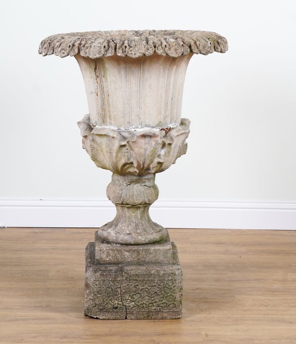 A COMPOSITON STONE URN ON PEDESTAL