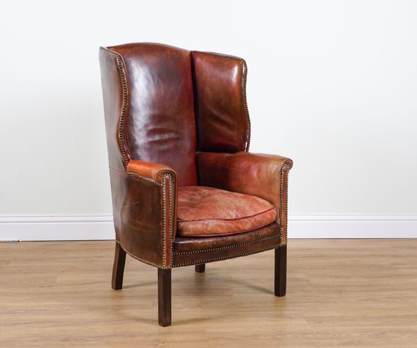 A GEORGE III STYLE LEATHER UPHOLSTERED WING BACK ARMCHAIR