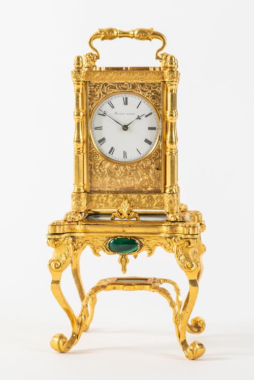 AN UNUSUAL ENGRAVED GILTBRASS AND MALACHITE MINIATURE TIMEPIECE WITH A MALACHITE-MOUNTED STAND