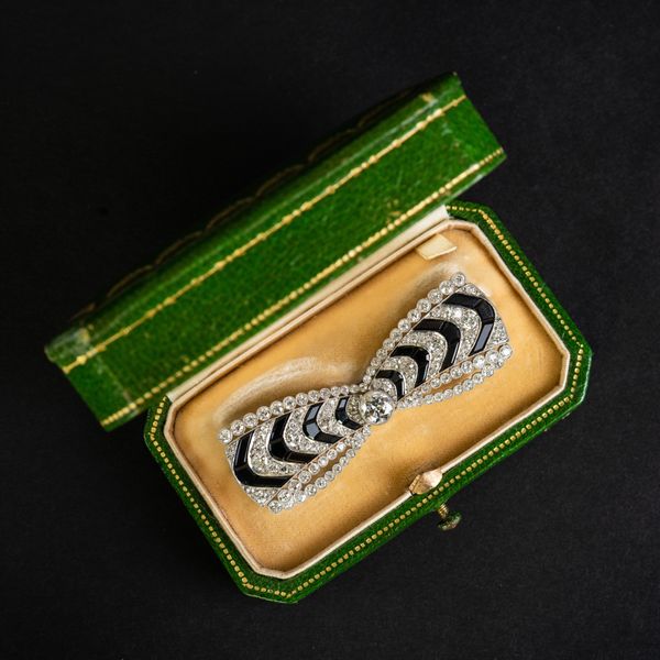 CARTIER - AN EARLY 20TH CENTURY DIAMOND AND ONYX BROOCH