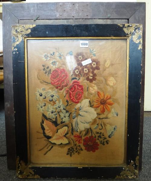 A Victorian needlework panel depicting still life flowers, 49cm x 38cm, and three further Victorian woolwork panels, all framed and glazed. (4)