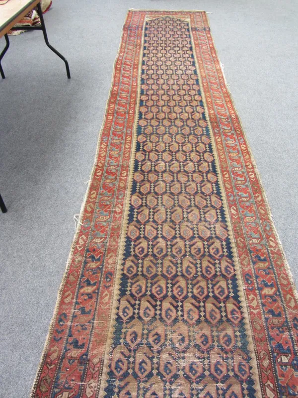 A Hamadan runner, Persian, the indigo field with rows of botehs, beige spandrels, a pale indigo and madder waved border, 530cm x 97cm.