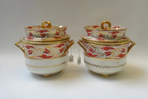 A pair of Coalport ice pails, covers and liners, circa 1810, set with angular handles and painted in iron red and gilt with foliate bands, raised on f