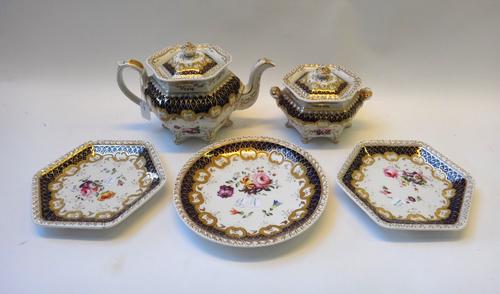A Ridgway porcelain part tea service, circa 1825-30, painted with flower sprays inside deep cream, blue and gilt borders, comprising; an hexagonal tea
