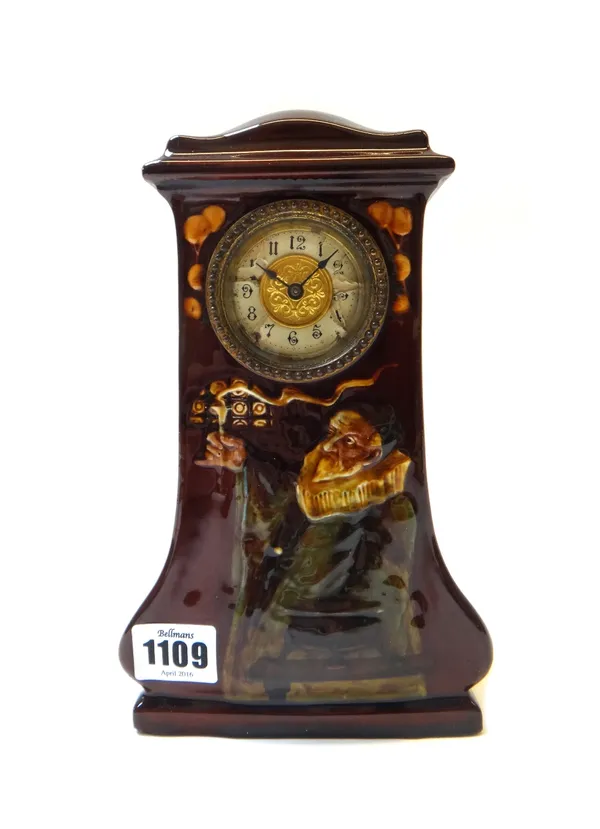 A Royal Doulton Art Nouveau kingsware clock designed by C. Noke, circa 1913, relief decorated with an alchemist against a brown ground, unsigned, 23cm