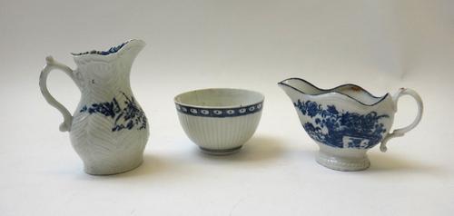 A Worcester blue and white porcelain milk jug, circa 1756-58, moulded all over with feathers and painted with flower sprays, with workman's mark, 9.5c