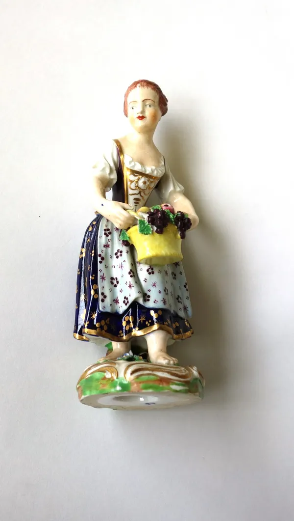 A Derby porcelain figure, early 19th century, modelled as a lady with a basket of fruit, 15cm high, together with a porcelain bust titled 'Voltaire',