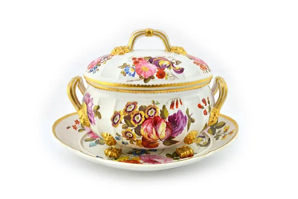 A Derby oval two-handled sauce tureen, cover and stand, circa 1815, painted with groups of colourful flowers inside gilt dentil rims, red painted crow