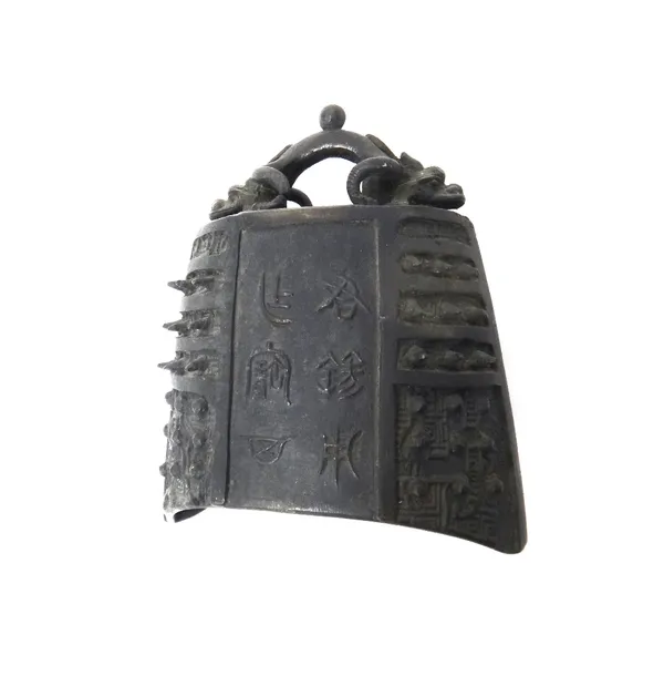 A Chinese archaic style bronze bell, 20th century, cast with panels of studs and script, the loop cast as a twin-headed dragon, 18cm. high.