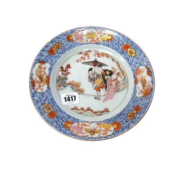 A Chinese rose-Imari plate, Yongzheng, painted with a lady and servant holding a parasol in a garden, the border reserved with panels of insects and f