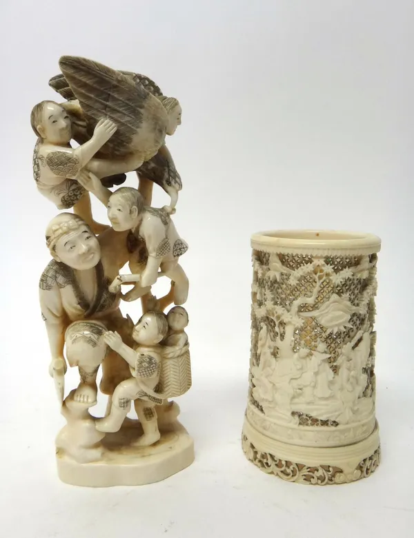 A Japanese ivory okimono, Meiji period, carved as a man carrying an axe and surrounded by five children and a bird, 20cm. high, together with a Canton