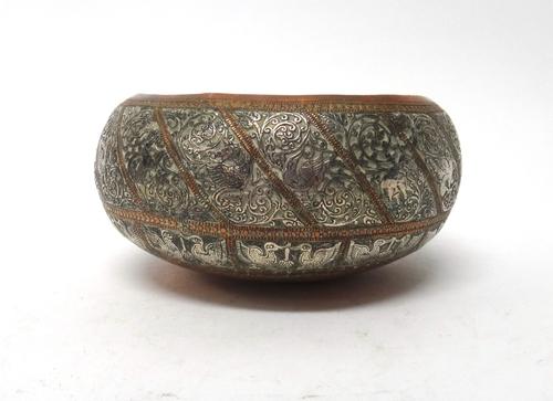 A silver-inlaid copper bowl, probably 19th century, the exterior with diagonal panels enclosing birds and animals, against a foliate ground above pane