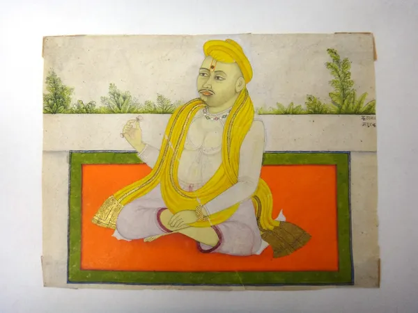 A seated yogi, North India, early 19th century, opaque pigments heightened with gold on paper, holding a flower in his right hand, mounted, 15.3cm. x