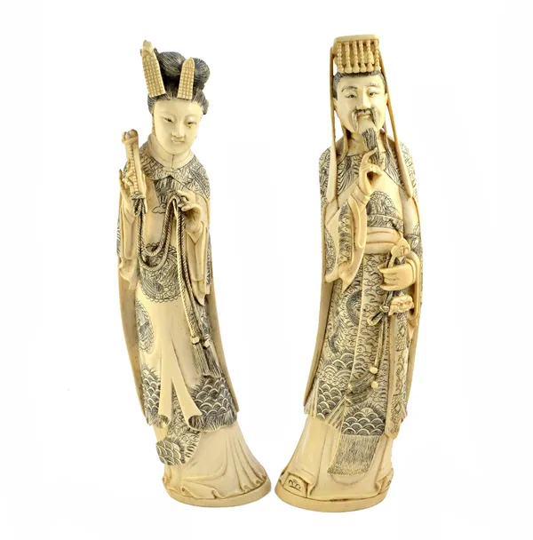 A pair of Chinese ivory figures of an Emperor and Empress, early 20th century, each standing wearing Imperial robes, signed, 35cm. high.   Illustrated