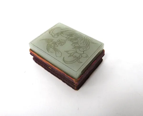 A Chinese pale celadon jade belt slide, 19th century, carved in low relief with several chicks nesting within a lotus leaf, the mother pecking at a lo