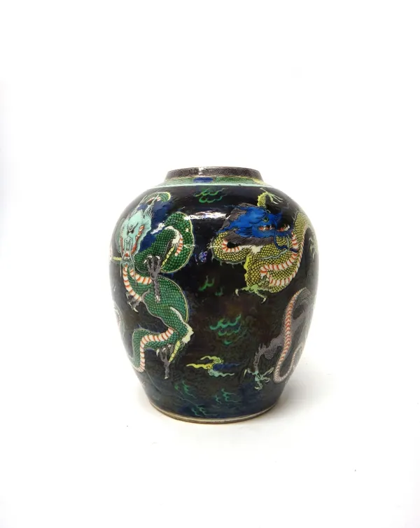 A Chinese porcelain ovoid jar, late 19th century, painted with five dragons amidst cloud scrolls against a black ground, 23cm. high.