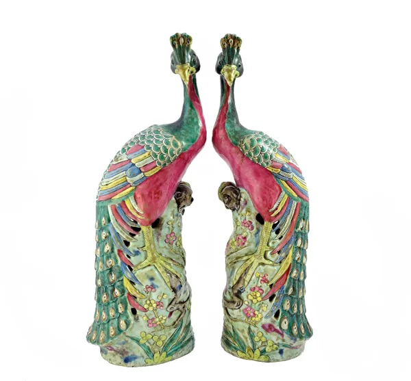 A pair of Chinese famille-rose figures of peacocks, late 19th century, each perched on a tall pierced rockwork painted with flowering prunus, 32cm. hi