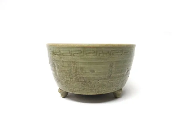 A Chinese celadon glazed censer, Qing Dynasty, of cylindrical form, raised on three scroll supports, moulded on the exterior with the trigrams beneath