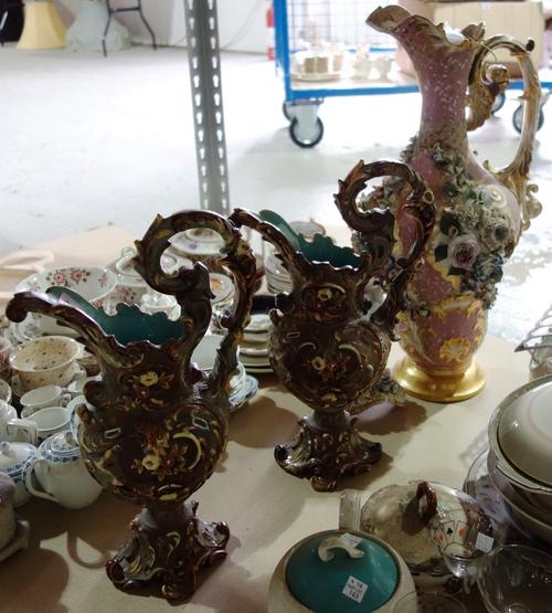 A pair of majolica decorated ceramic ewers and a large Paris porcelain ewer. (3)