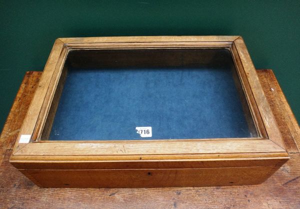 An early 20th century oak framed rectangular table top display cabinet with glazed lift top, 50cm wide.