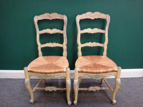 A set of ten French 19th century yellow and blue painted dining chairs with shell carved crest and rush seat on cabriole supports.