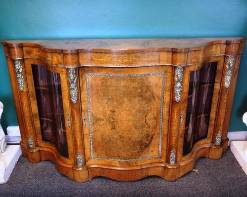 A Victorian gilt metal mounted, marquetry inlaid figured walnut credenza, with panel central door, flanked by glazed serpentine doors on plinth base,