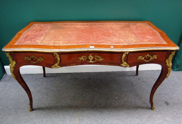 A late 19th century gilt metal mounted mahogany bureau plat of Louis XV design with serpentine top with three frieze drawers and opposing dummy drawer