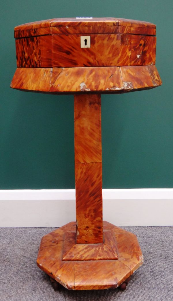 An early Victorian blonde tortoiseshell work box on stand, with octagonal lift top on square column and further octagonal base, 37cm wide x 67cm high.