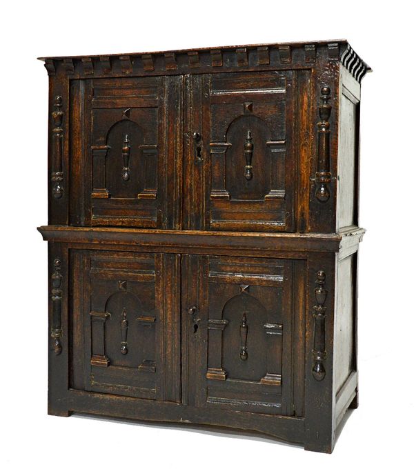 A 17th century oak four door cupboard of small proportions, with arcaded moulded doors and split bobbin mounts, 70cm wide x 82cm high.  Illustrated