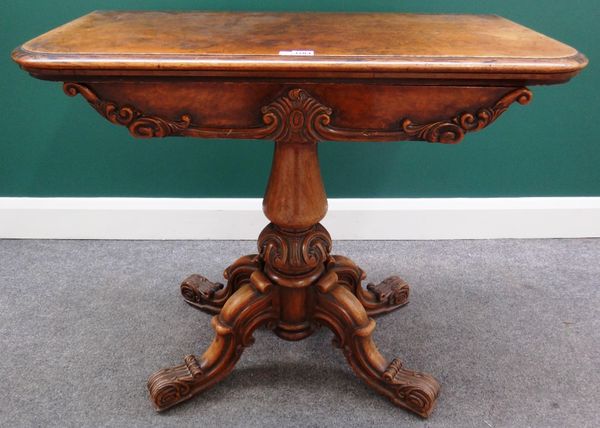 A Victorian figured walnut card table with carved frieze, on turned column and four scroll supports, 92cm wide.