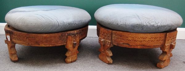 A pair of early 20th century carved hardwood circular braziers/footstools, each on four shaped supports, 80cm wide.