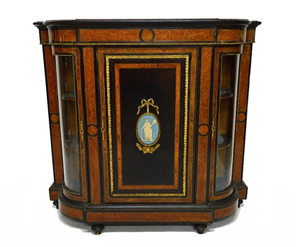 A Victorian gilt metal mounted amboyna side cabinet, the panelled central door with oval Jasperware panel flanked by a pair of rounded glazed doors, 1