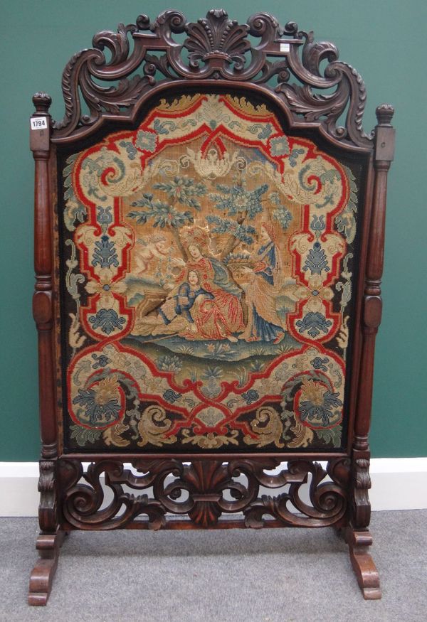 A William and Mary pierced and carved walnut framed tapestry fire screen, on later 19th century turned rosewood supports, 75cm wide x 121cm high.