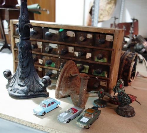 A Baldwin cast iron door step, a group of Dinky and Corgi toy cars, three Eastern polychrome stone set birds and a bank of drawers and an iron. (qty)