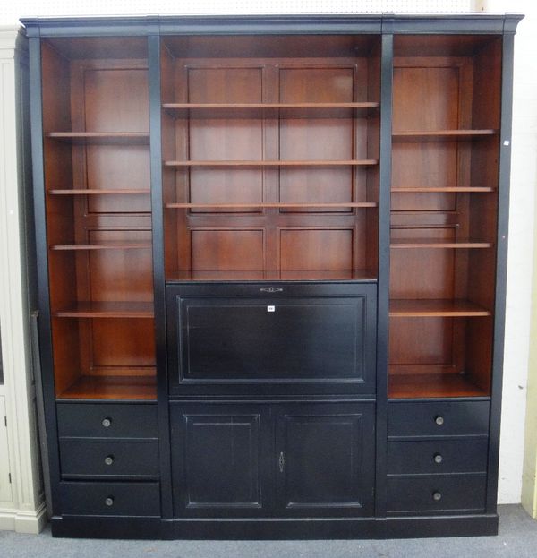 A 20th century ebonised bookcase, with an arrangement of open shelves and drawers, centred by a drop flap writing compartment, 223cm wide x 243cm high