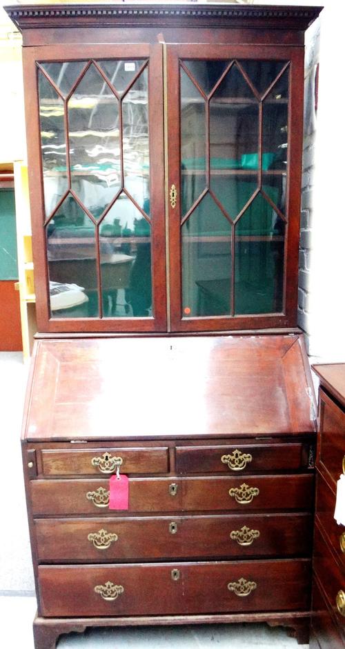 A George III mahogany bureau bookcase, with a pair of astragal glazed doors over a fitted interior, two short and three long graduated drawers on brac