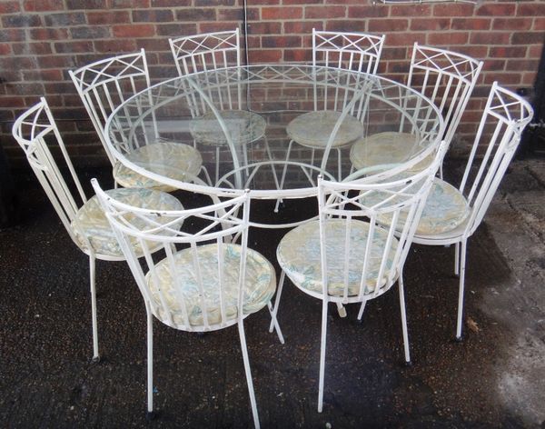 A 20th century white painted metal glass topped circular garden table, 125cm wide, together with eight matching chairs.