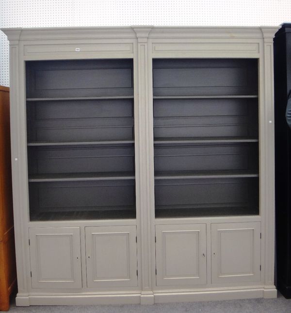 A 20th century double section grey painted bookcase cupboard, the open shelves over four cupboards on plinth base 240cm wide x 240cm high.