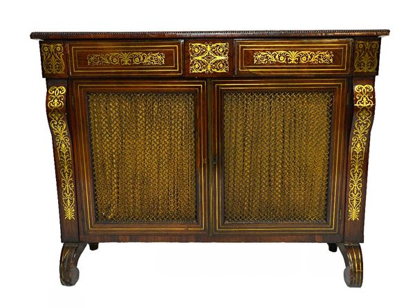 A Regency brass inlaid rosewood chiffonier with a pair of frieze drawers over a pair of grille doors on downswept supports, 120cm wide.   Illustrated