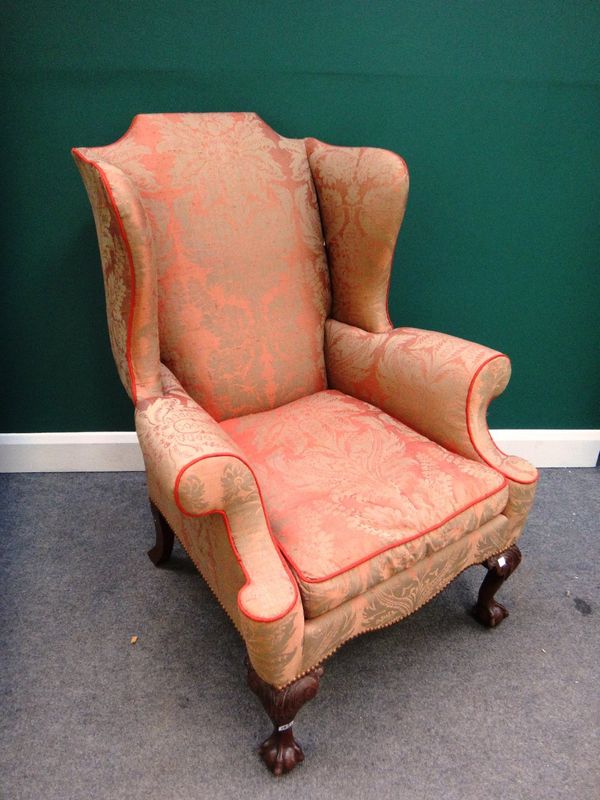 A George I style wingback armchair, on mahogany claw and ball feet.